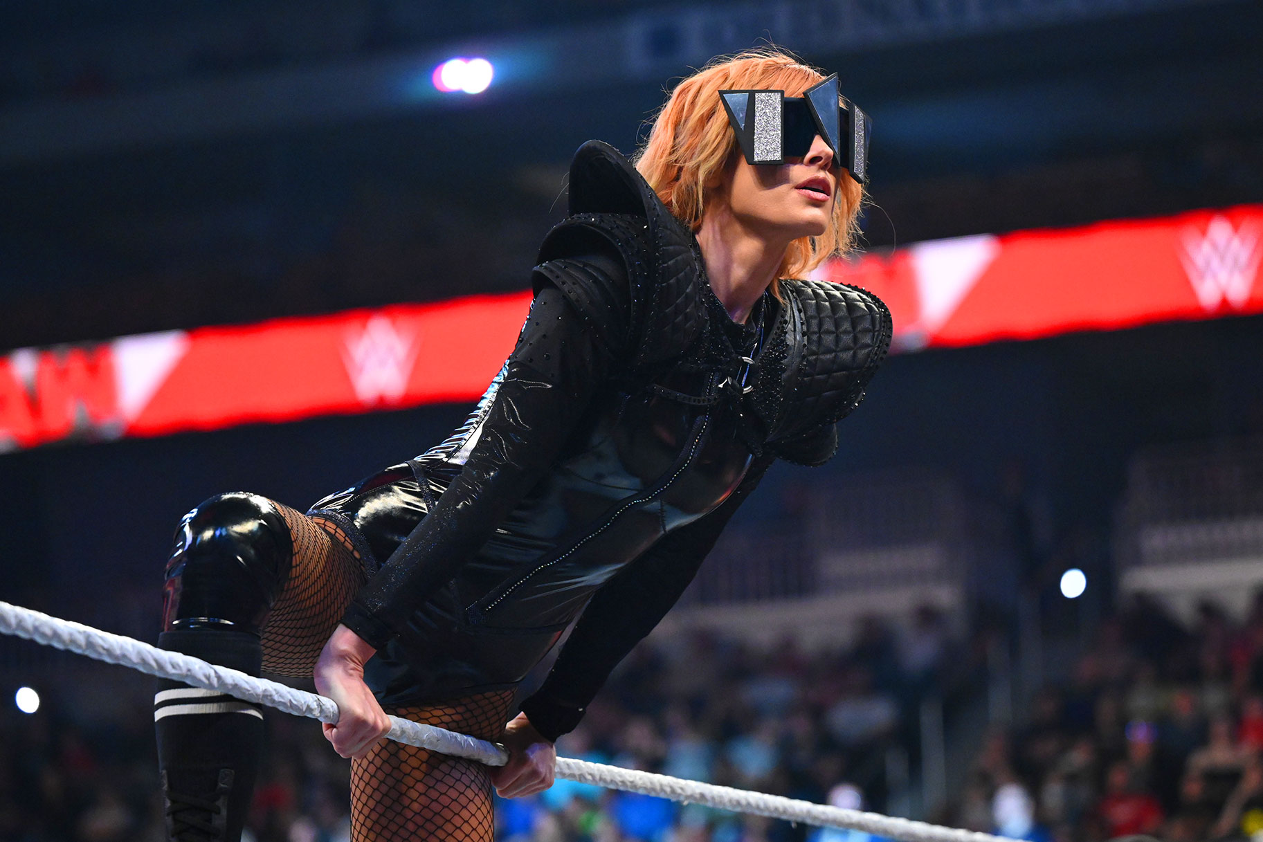 WWE Becky Lynch leaning against the ropes of the ring