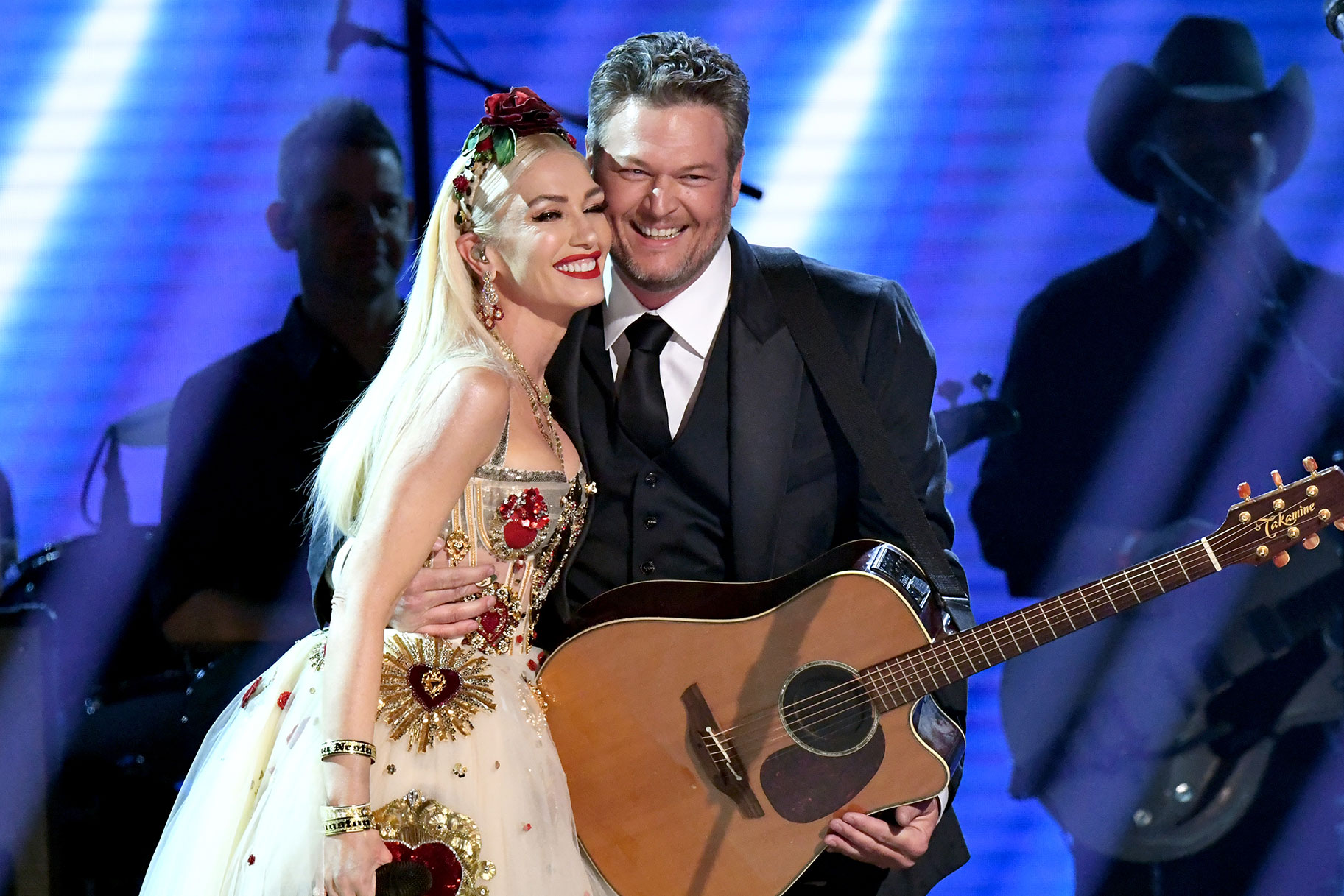 Blake Shelton and Gwen Stefani onstage hugging and smiling