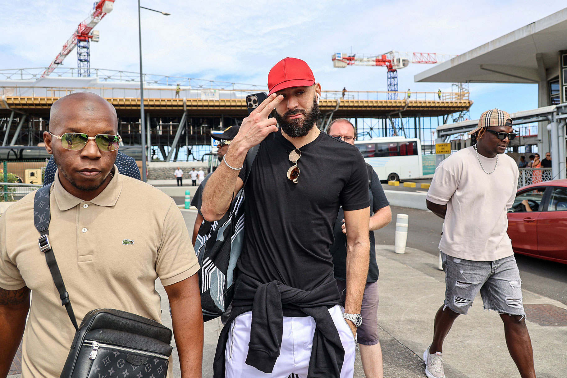 French footballer Karim Benzema gestures as he arrives at La Reunion's Roland-Garros airport in Sainte-Marie