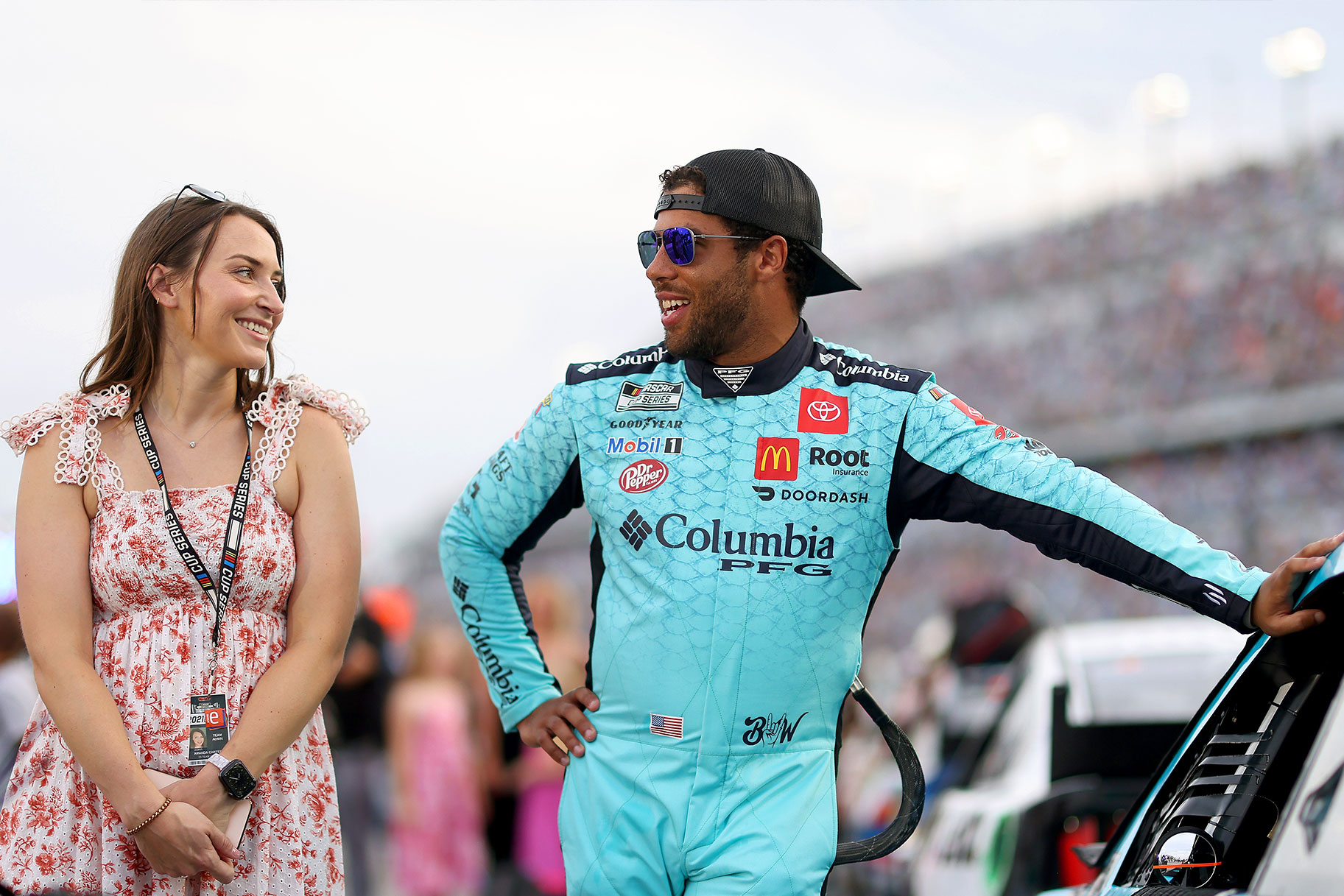 Bubba Wallace, driver of the #23 Columbia PFG Toyota, and fiance Amanda Carter talk on the grid prior to the NASCAR Cup Series Coke Zero Sugar 400 at Daytona International Speedwa