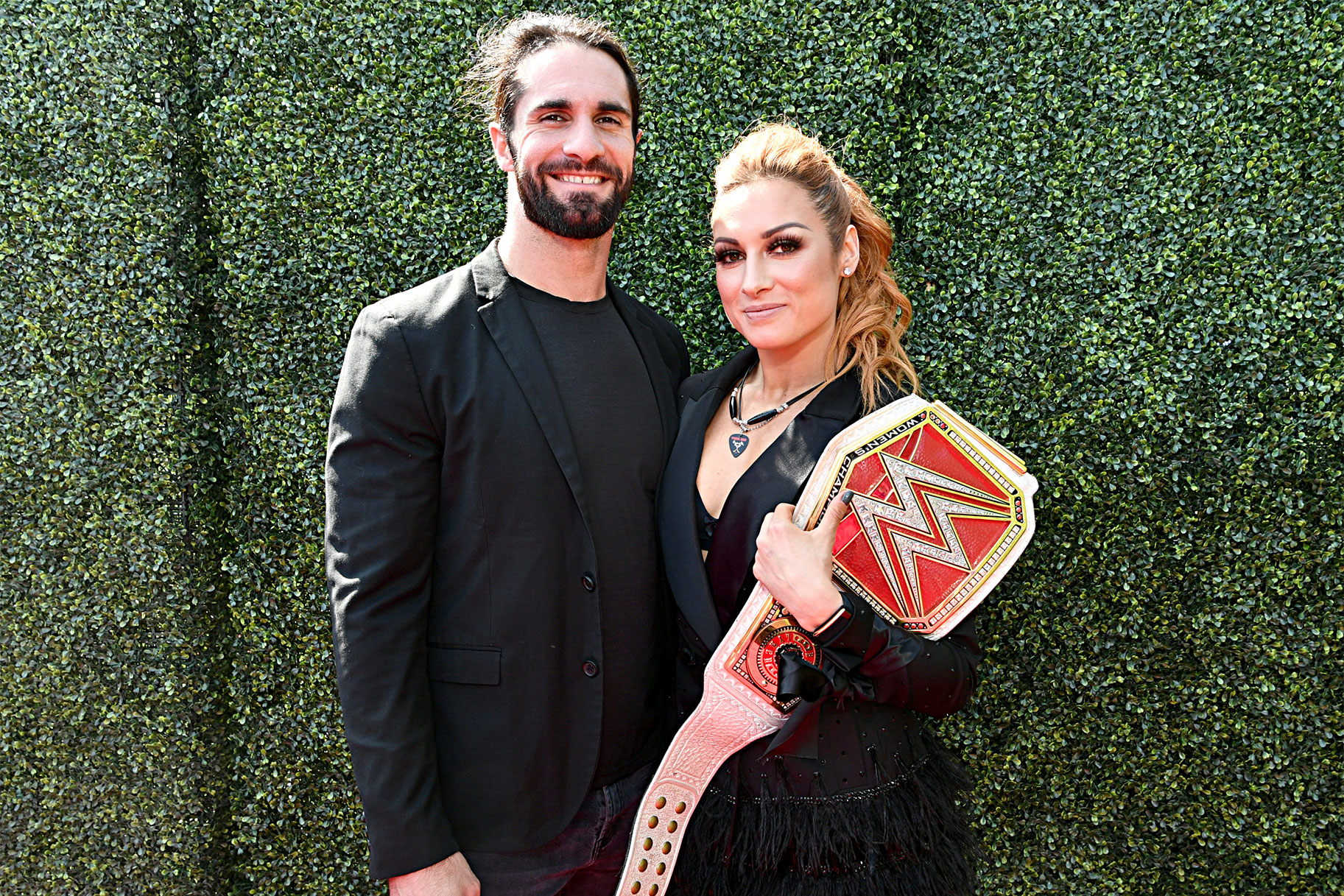 Becky Lynch and Seth Rollins pose for a red carpet photo at an event.