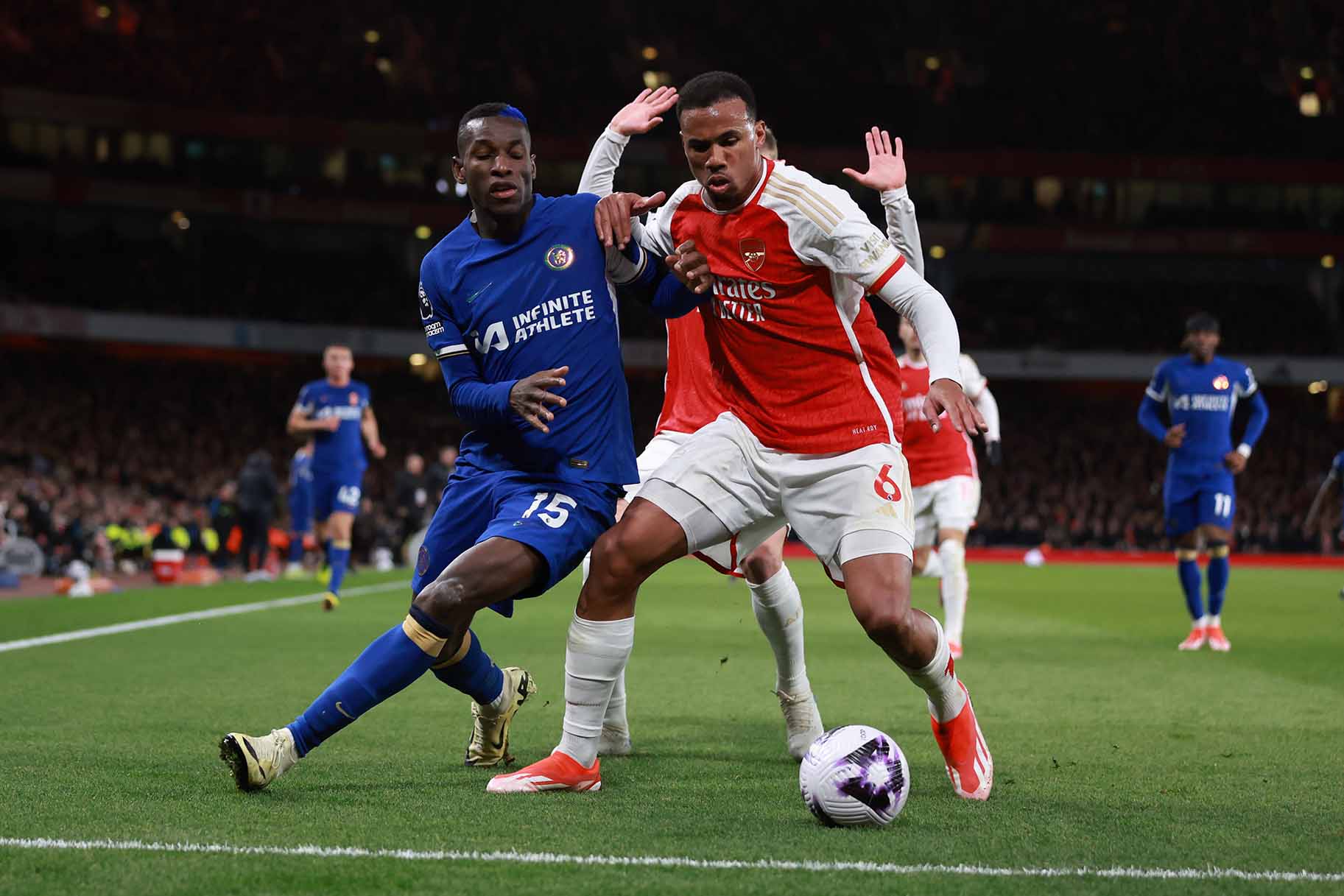 Gabriel Magalhaes of Arsenal tangles with Nicolas Jackson of Chelsea fight for the ball during a game.