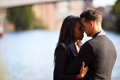 Nicole and Daniel cuddling in front of a river