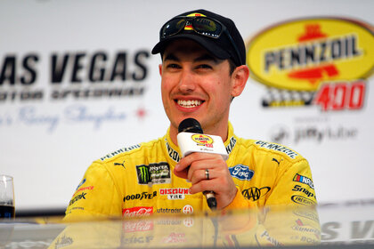 Joey Logano smiling while talking to press