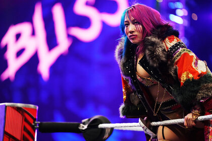 Asuka leaning on the top rope of the ring