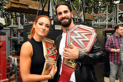 Becky Lynch adn Seth Rollins pose for a red carpet photo at an event.