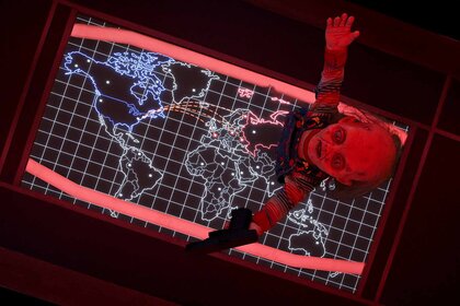 Chucky stands on top of a world map in Chucky Episode 306.