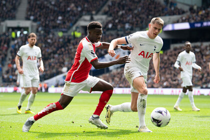 Bukayo Saka of Arsenal battles with Mickey van de Ven of Tottenham Hotspur