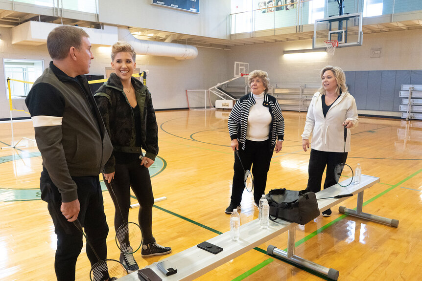 The Chrisley Family in a gym, looking at each other with badminton rackets in their hands