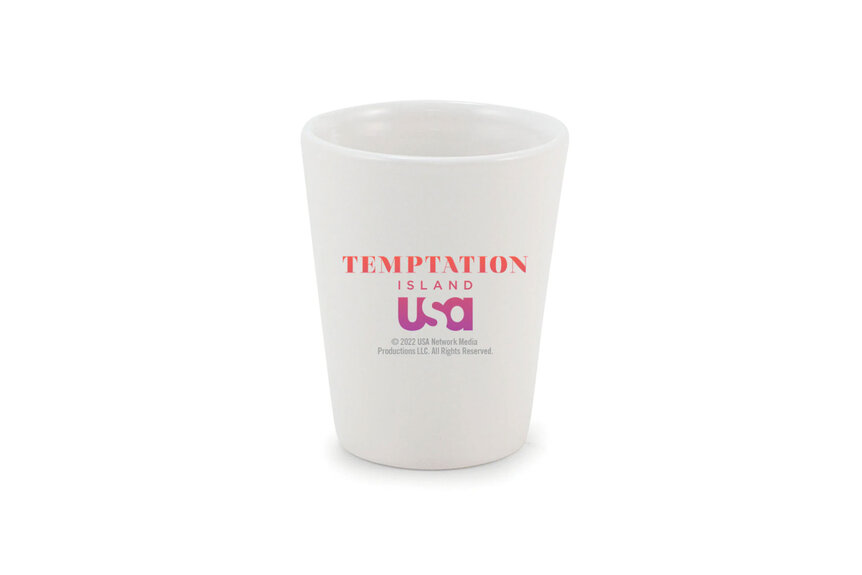 White shot glass that has the tempation island logo on it