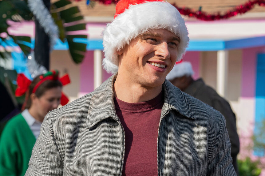 911's Oliver Stark smiling, wearing a santa hat