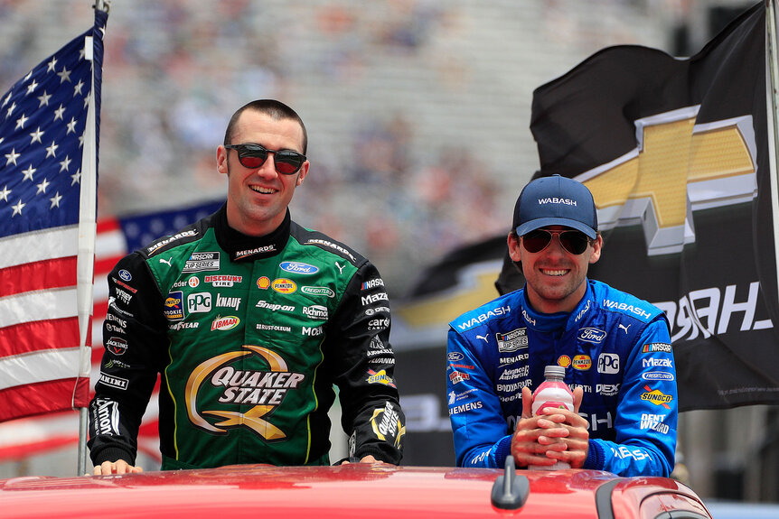 Austin Cindric and Ryan Blaney smiling while standing together