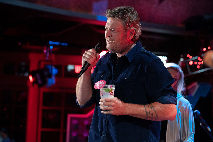 Blake Shelton holding a drink in his hands