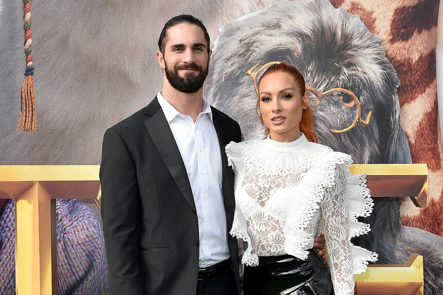 Becky Lynch and Seth Rollins pose for a red carpet photo at an event.