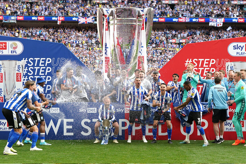 Sheffield United players celebrate with the trophy following victory in the Sky Bet League One play-off final