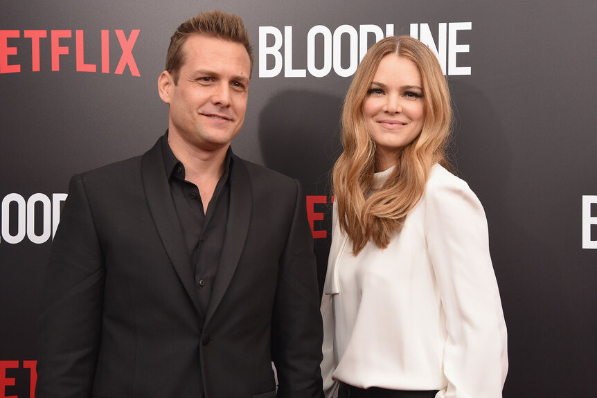 Gabrielle Macht and Jacinda Barrett stand on the red carpet of a Netflix premiere event