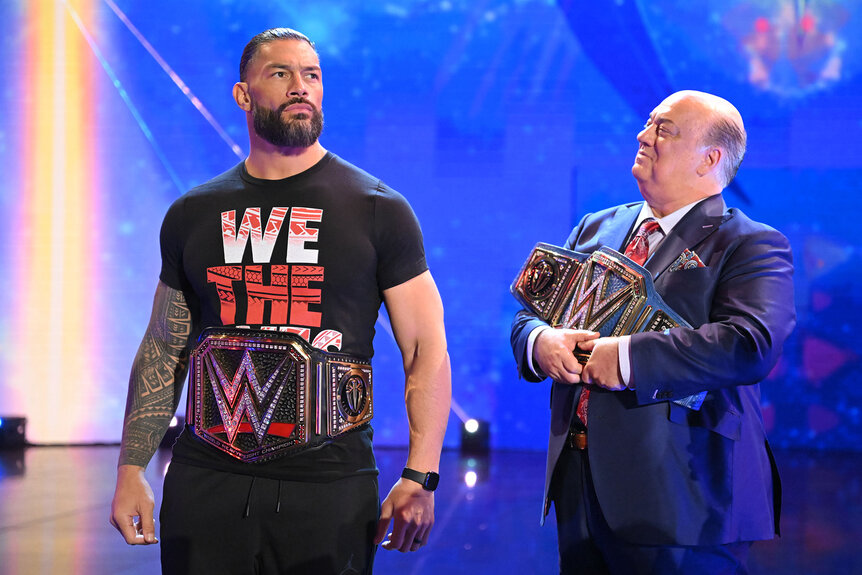 Roman Reigns with his two title belts