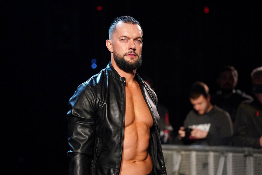 Finn Balor stands outside of the ring