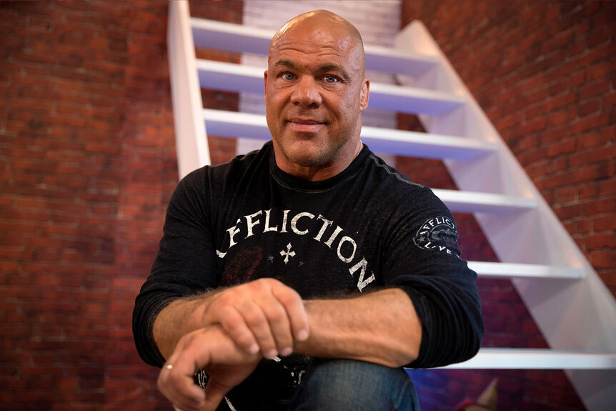 Kurt Angle sits on steps posing for photo