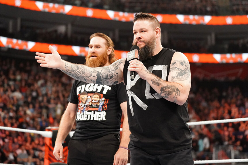 Sami Zayn and Kevin Owens speak to someone out of frame while standing in the ring