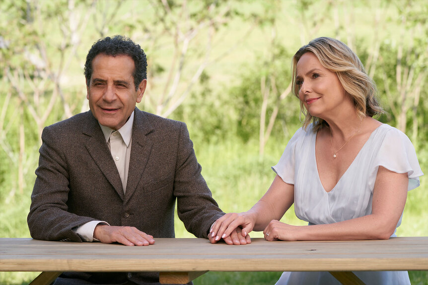 Tony Shalhoub as Adrian Monk and Melora Hardin as Trudy sit together at a table outside