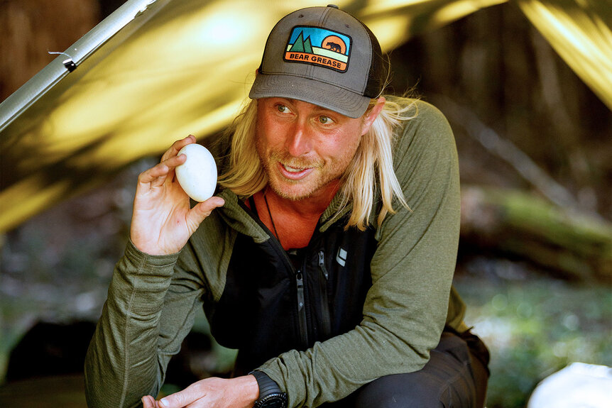 Creighton Baird holds up an egg in Race to Survive: New Zealand