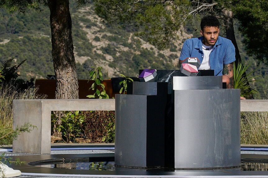 Marcel Cunningham stands at a podium in The Anonymous, Season 1 Episode 3.