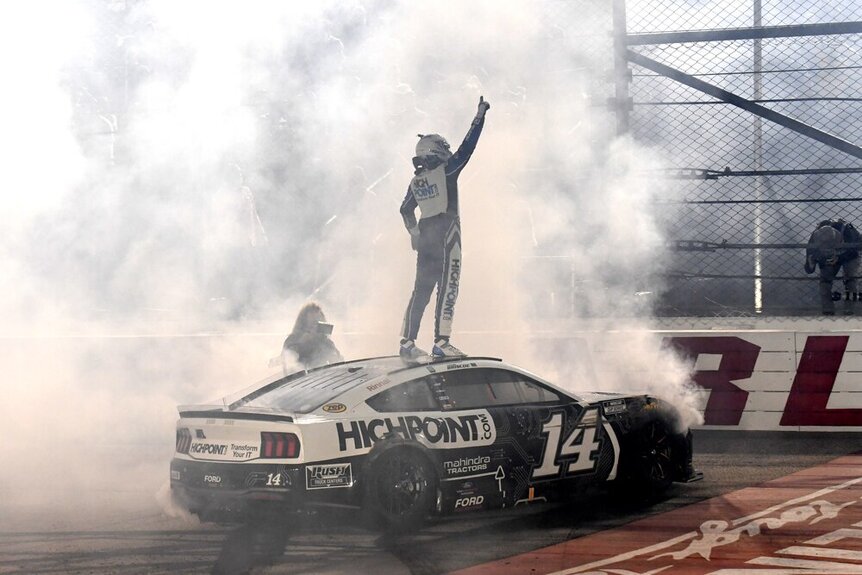 Chase Briscoe standing on top of his car celebrating after the race