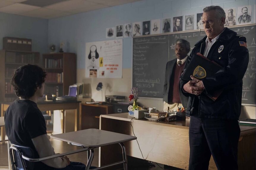 Chief Dandridge (Bruce Campbell) stands at the front of a classroom and stares at Dylan Campbell (Emjay Anthony) on Hysteria! Episode 105.