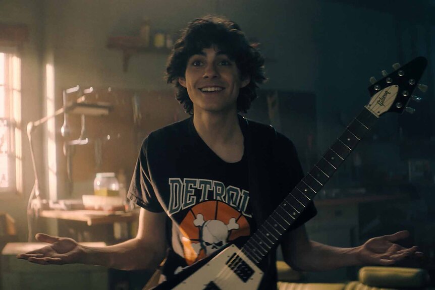 Dylan Campbell (Emjay Anthony) wears an electric guitar on Hysteria! Episode 101.